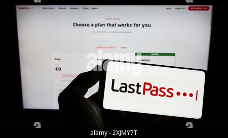 Stuttgart, Germany, 12-30-2022: Person holding mobile phnoe with logo of password management company LastPass US LP on screen in front of web page. Stock Photo