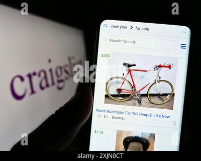 Stuttgart, Germany, 01-08-2023: Person holding cellphone with webpage of classified advertisements company Craigslist Inc. on screen with logo. Focus Stock Photo