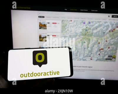 Stuttgart, Germany, 01-11-2023: Person holding cellphone with logo of outdoor platform company Outdooractive AG on screen in front of business Stock Photo