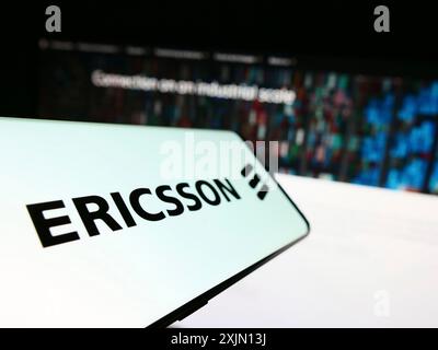 Stuttgart, Germany, 01-11-2023: Mobile phone with logo of Swedish telecommunications company Ericsson on screen in front of website. Focus on Stock Photo