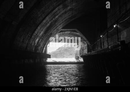 Exit gateway of an undeground concrete tunnel interior. Abandoned underground submarine base from USSR period located in Balaklava, Crimea. Industrial Stock Photo