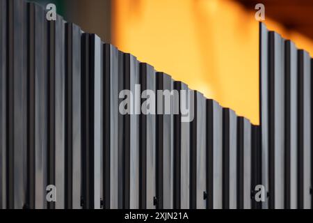 Shiny ridged gray metal fence, abstract background photo with selective soft focus Stock Photo