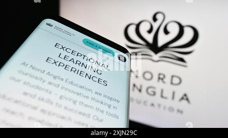 Stuttgart, Germany, 03-08-2023: Smartphone with webpage of schooling company Nord Anglia Education Limited on screen in front of logo. Focus on Stock Photo