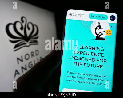 Stuttgart, Germany, 03-08-2023: Person holding cellphone with website of schooling company Nord Anglia Education Limited on screen with logo. Focus Stock Photo