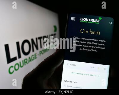 Stuttgart, Germany, 03-08-2023: Person holding smartphone with webpage of British company Liontrust Asset Management plc on screen with logo. Focus Stock Photo