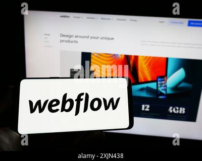 Stuttgart, Germany, 03-31-2023: Person holding cellphone with logo of American web development software company Webflow Inc. on screen with website. Stock Photo