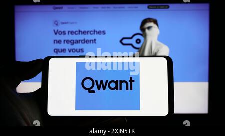 Stuttgart, Germany, 04-23-2023: Person holding cellphone with logo of French search engine company Qwant SAS on screen in front of business webpage. Stock Photo