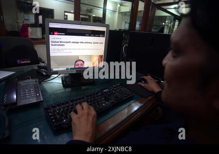 A man reads news of Microsoft global outage on a computer screen in