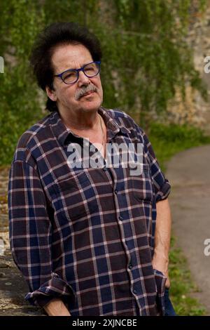 Good looking man with glasses in front of a stone wall. Stock Photo