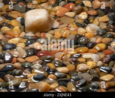 Macro photo of smooth multi-colored rocks in a small amount of water Stock Photo