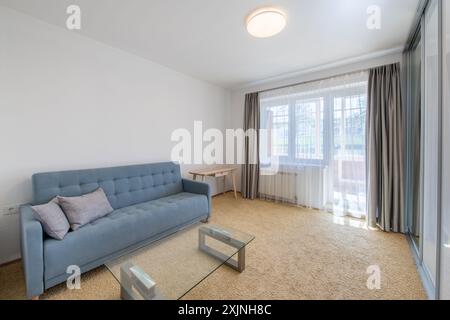 Minimalism Children, Young Adult Living Room Interior. Couch and Table. Windows and Curtains. Coffee Table, Carpet. Stock Photo