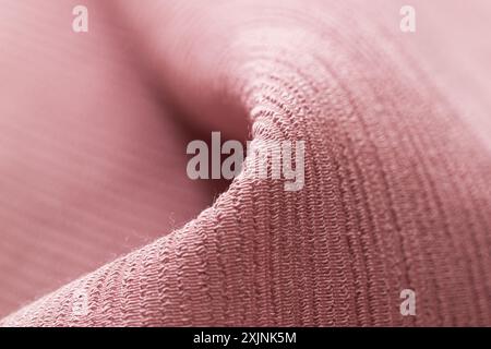 Close-up texture of soft pink fabric, ideal for backgrounds and textile design. Stock Photo