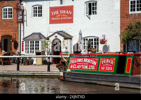 Former working canal narrowboat  Perch, moored outside the Swan inn public house on the Trent and Mersey canal at Fradley Junction Staffordshire Stock Photo