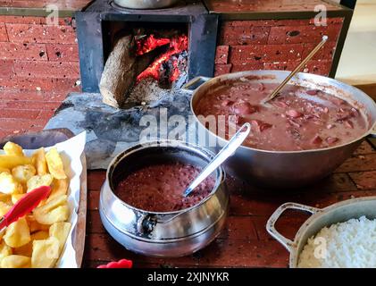 feijoada cooked in a wood stove with rice and farofa Stock Photo