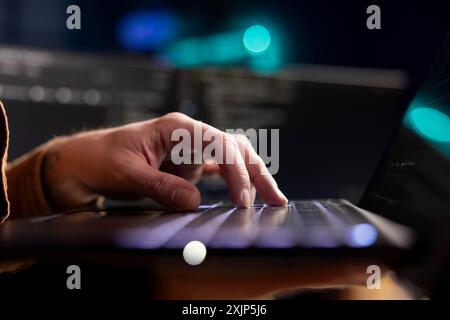 Cybersecurity expert using laptop to look for company security vulnerabilities and prevent malware infections. Developer installing fortified code on notebook to prevent cyberattacks, close up shot Stock Photo
