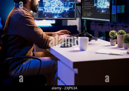 Freelancing computer engineer doing maintenance on artificial intelligence neural networks computerized model. Remote tech support specialist at working from home, doing checkup on AI systems Stock Photo