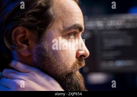 Cybersecurity expert in apartment using computer to look for security liabilities. Programmer focused on installing safeguard code on PC to prevent firewall breaches, close up shot Stock Photo