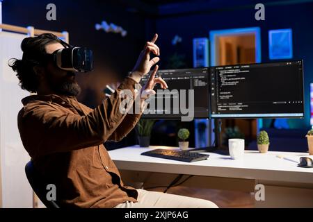 Cybersecurity specialist using VR headset to look for company security vulnerabilities and prevent malware infections. Programmer preventing PC cyber attacks using virtual reality technology Stock Photo