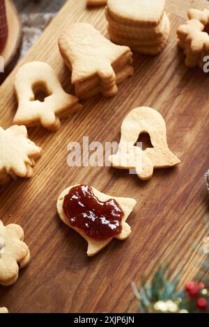Filling a bell shaped Linzer Christmas cookie with strawberry jam Stock Photo