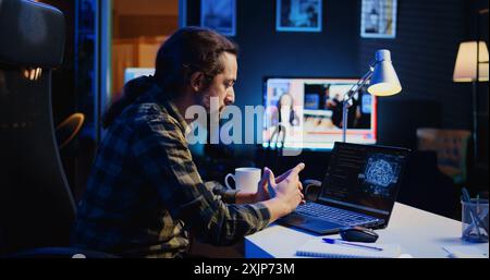 Man in home office typing on keyboard, updating artificial intelligence neural networks, writing complex binary code scripts. Freelancer in personal office upgrading high tech AI, camera B Stock Photo