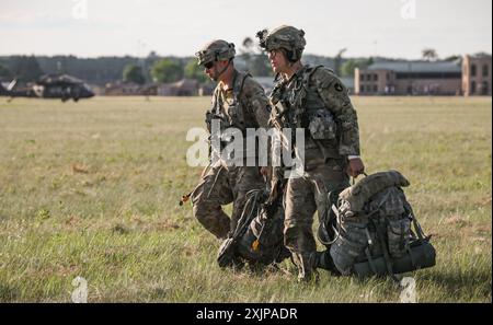 Iowa Army National Guard Soldiers assigned to the 1st Battalion, 168th Infantry Regiment, 2nd Brigade Combat Team, 34th Infantry Division, move to a pre-loading location during an air assault exercise at Camp Ripley, Minn., on July 18, 2024. The 2/34th IBCT is completing an eXportable Combat Training Capabilities rotation, which trains Soldiers in dynamic and challenging scenarios and certifies their platoon proficiencies. (U.S. Army National Guard photo by Sgt. 1st Class Tawny Kruse) Stock Photo