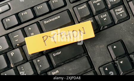 Concept of Python write on sticky notes isolated on Wooden Table. Stock Photo