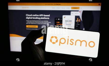 Stuttgart, Germany, 07-08-2023: Person holding cellphone with logo of company Pismo Solucoes Tecnologicas Ltda. on screen in front of business Stock Photo