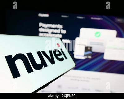 Stuttgart, Germany, 07-08-2023: Cellphone with logo of Canadian payments company Nuvei Technologies Corp. on screen in front of business website. Stock Photo