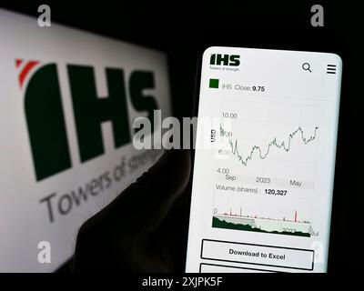 Stuttgart, Germany, 07-08-2023: Person holding cellphone with website of telecommunications company IHS Holding Limited on screen with logo. Focus on Stock Photo