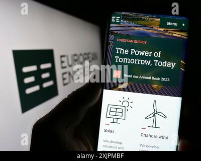 Stuttgart, Germany, 07-27-2023: Person holding smartphone with webpage of Danish renewables company European Energy AS on screen with logo. Focus on Stock Photo