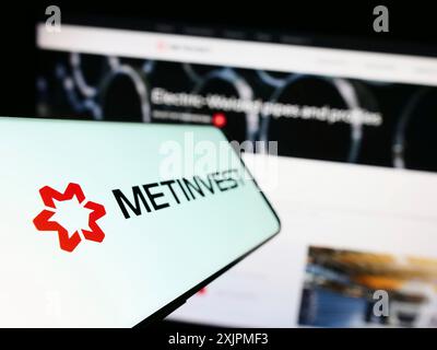 Stuttgart, Germany, 07-27-2023: Smartphone with logo of steel company Ukrainian Metinvest Holding LLC on screen in front of business website. Focus Stock Photo