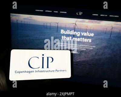 Stuttgart, Germany, 07-28-2023: Person holding smartphone with logo of Copenhagen Infrastructure Partners PS (CIP) on screen in front of website. Stock Photo