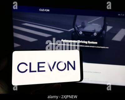 Stuttgart, Germany, 08-05-2023: Person holding smartphone with logo of Estionian autonomous vehicle company Clevon AS on screen in front of website. Stock Photo