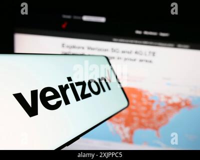 Stuttgart, Germany, 08-12-2023: Smartphone with logo of American company Verizon Communications Inc. on screen in front of business website. Focus on Stock Photo