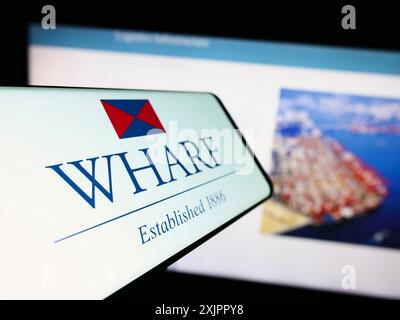 Stuttgart, Germany, 08-17-2023: Mobile phone with logo of Chinese company The Wharf Holdings Limited on screen in front of website. Focus on Stock Photo