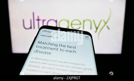 Stuttgart, Germany, 08-26-2023: Smartphone with website of US company Ultragenyx Pharmaceutical Inc. on screen in front of business logo. Focus on Stock Photo