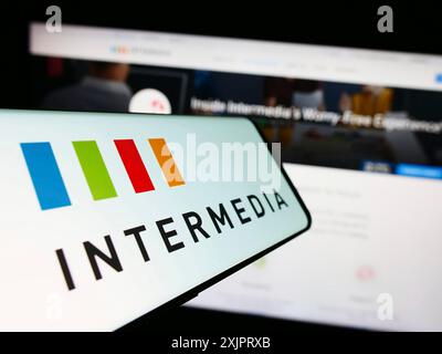 Stuttgart, Germany, 08-28-2023: Cellphone with logo of American company Intermedia Cloud Communications on screen in front of website. Focus on Stock Photo