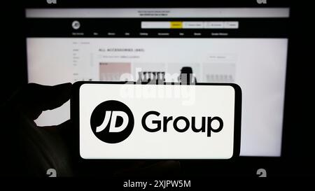 Stuttgart, Germany, 09-19-2023: Person holding cellphone with logo of British retail company JD Sports Fashion plc on screen in front of webpage. Stock Photo