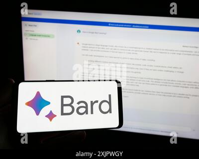 Stuttgart, Germany, 09-23-2023: Person holding smartphone with logo of generative AI chatbot Google Bard on screen in front of website. Focus on Stock Photo