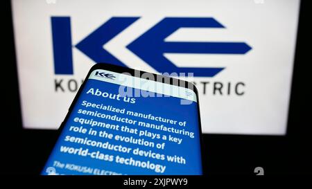 Stuttgart, Germany, 09-24-2023: Smartphone with website of Japanese company Kokusai Electric Corporation on screen in front of business logo. Focus Stock Photo