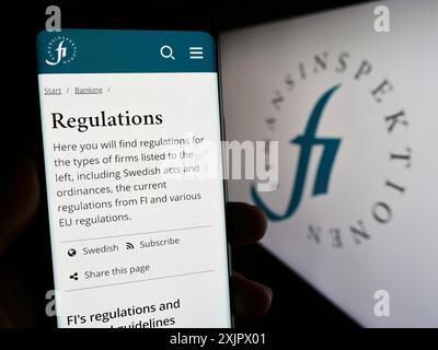 Stuttgart, Germany, 09-24-2023: Person holding cellphone with web page of Swedish financial regulator Finansinspektionen on screen with logo. Focus Stock Photo