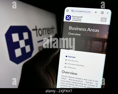 Stuttgart, Germany, 10-11-2023: Person holding cellphone with webpage of Indian company Torrent Pharmaceuticals Limited in front of logo. Focus on Stock Photo