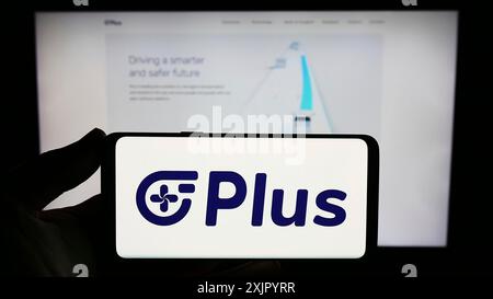 Stuttgart, Germany, 10-31-2023: Person holding smartphone with logo of US autonomous trucking company PlusAI Inc. in front of website. Focus on phone Stock Photo