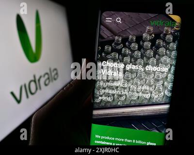 Stuttgart, Germany, 11-08-2023: Person holding cellphone with webpage of Spanish glass manufacturing company Vidrala S.A. in front of logo. Focus on Stock Photo