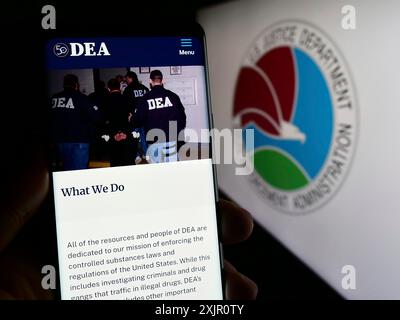 Stuttgart, Germany, 11-11-2023: Person holding cellphone with webpage of United States Drug Enforcement Administration (DEA) in front of seal. Focus Stock Photo