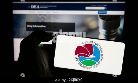 Stuttgart, Germany, 11-11-2023: Person holding mobile phone with seal of United States Drug Enforcement Administration (DEA) in front of web page. Stock Photo