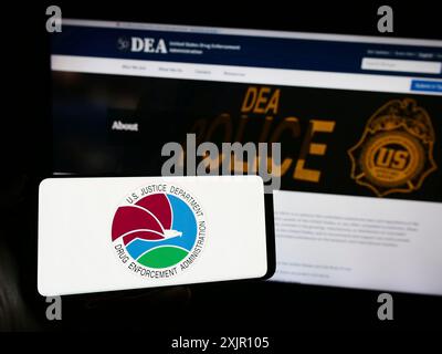 Stuttgart, Germany, 11-11-2023: Person holding smartphone with seal of United States Drug Enforcement Administration (DEA) in front of website. Focus Stock Photo