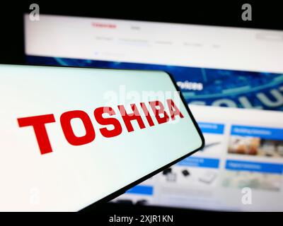 Stuttgart, Germany, 11-23-2023: Mobile phone with logo of Japanese electronics company Toshiba Corporation in front of business website. Focus on Stock Photo