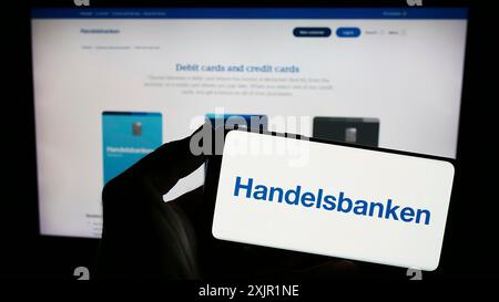 Stuttgart, Germany, 11-22-2023: Person holding smartphone with logo of Swedish financial company Svenska Handelsbanken AB in front of website. Focus Stock Photo