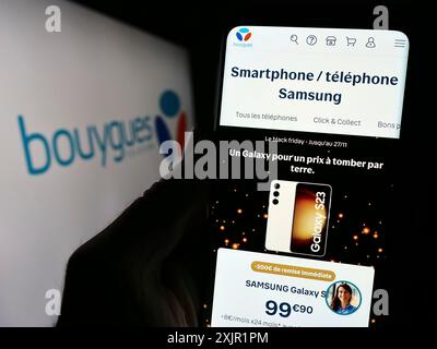 Stuttgart, Germany, 11-22-2023: Person holding cellphone with webpage of French telecommunications company Bouygues Telecom S.A. with logo. Focus on Stock Photo